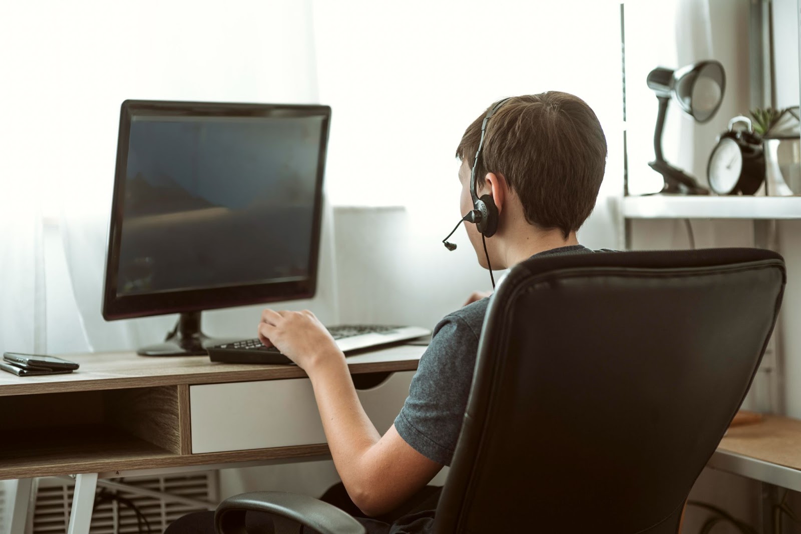 The guy with the headphones on is playing computer