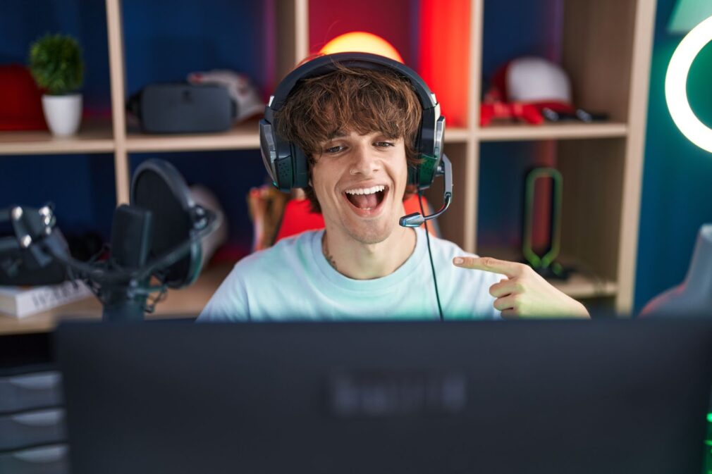 A man plays video games and smiles